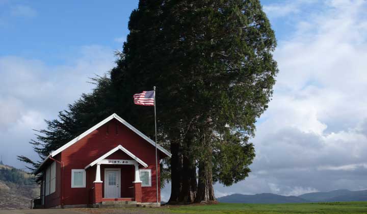 Red school house, American flag, photo