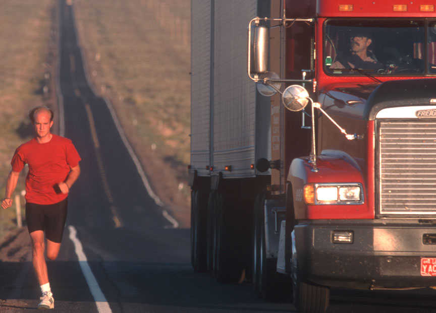 Red truck on Oregon highway with runner